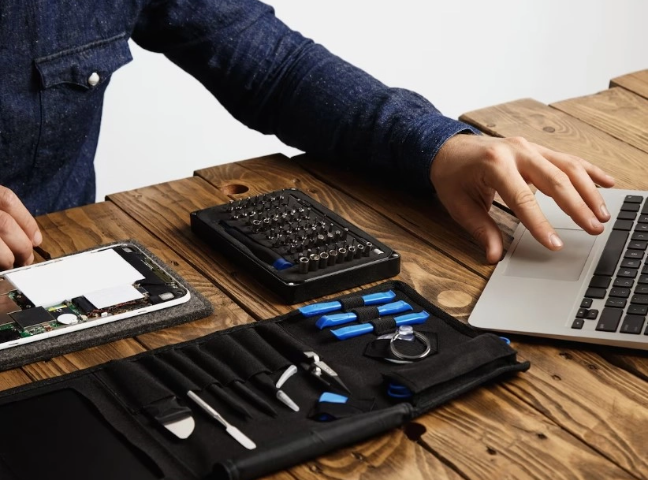 Technician working on laptop motherboard