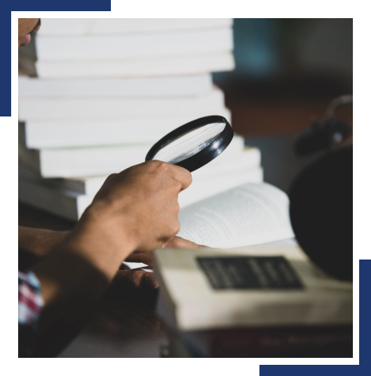 Man using Magnifying Glass on a Book